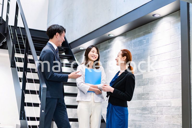 オフィスの階段で話をするビジネスパーソン