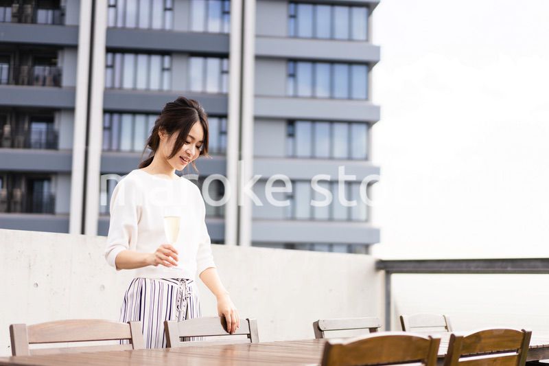 ペントハウスでワインを愉しむリッチな女性