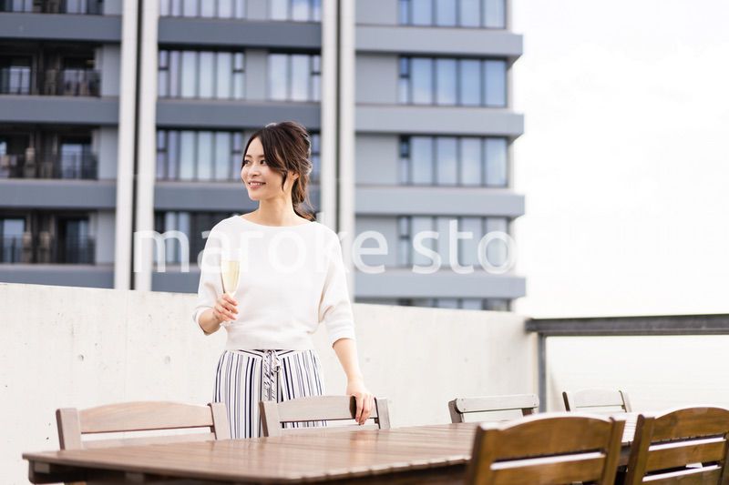 ペントハウスでワインを愉しむリッチな女性