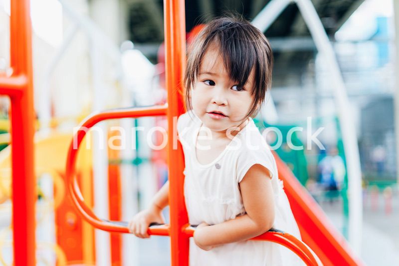 公園の遊具で遊ぶ小さな女の子