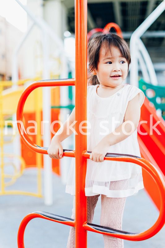 公園の遊具で遊ぶ小さな女の子