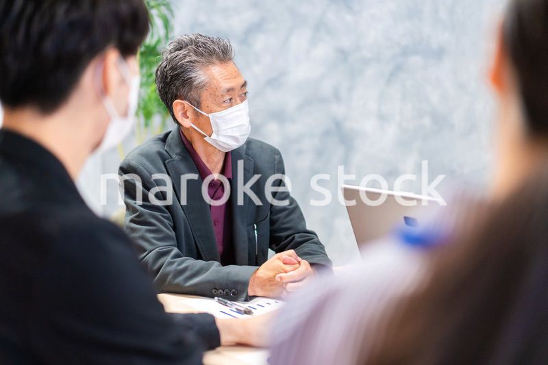 マスクをして会議をするビジネスパーソン