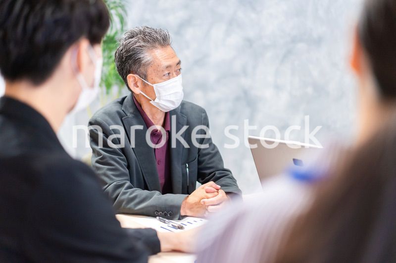 マスクをして会議をするビジネスパーソン