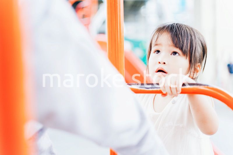 公園の遊具で遊ぶ小さな女の子