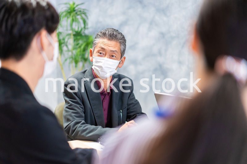 マスクをして会議をするビジネスパーソン