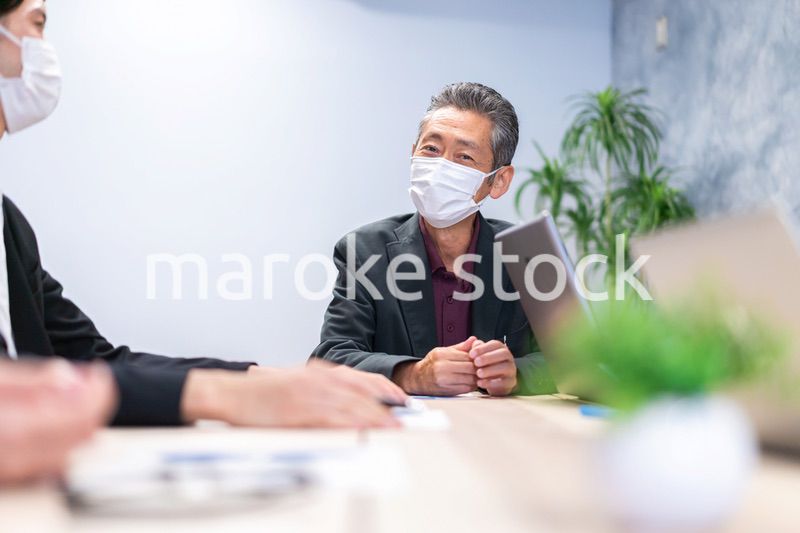 マスクをして会議をするビジネスパーソン