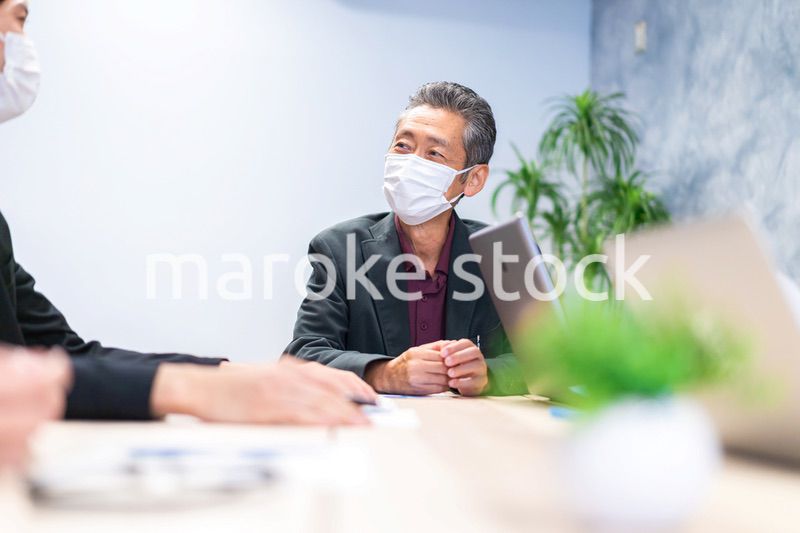 マスクをして会議をするビジネスパーソン