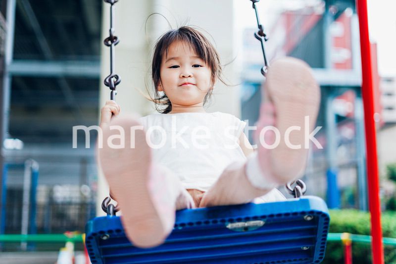 公園の遊具で遊ぶ小さな女の子