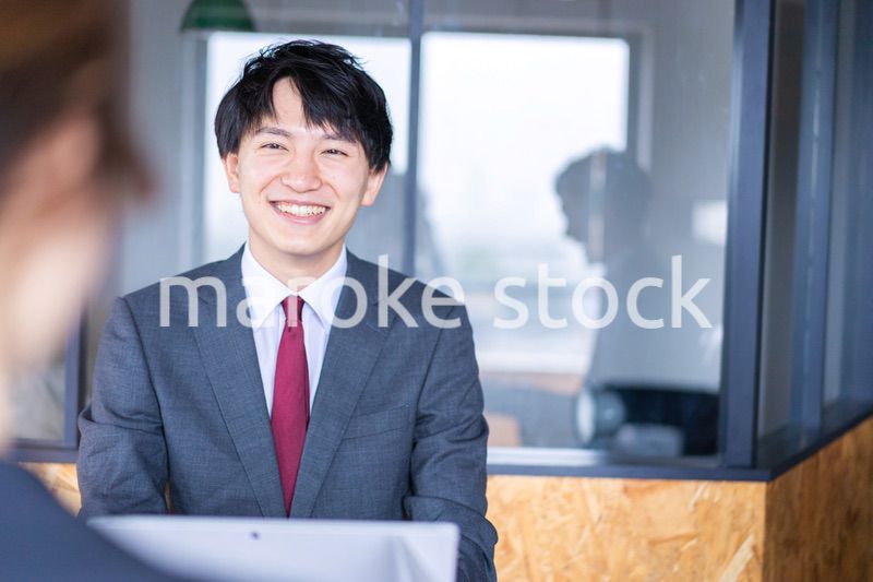 会議で発言をする若いビジネスマン