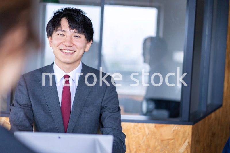 会議で発言をする若いビジネスマン