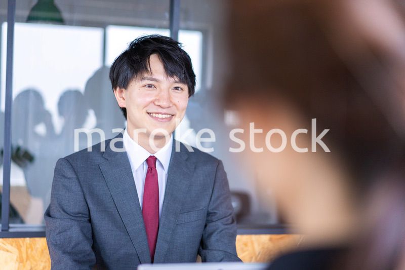 会議で発言をする若いビジネスマン