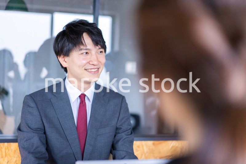 会議で発言をする若いビジネスマン