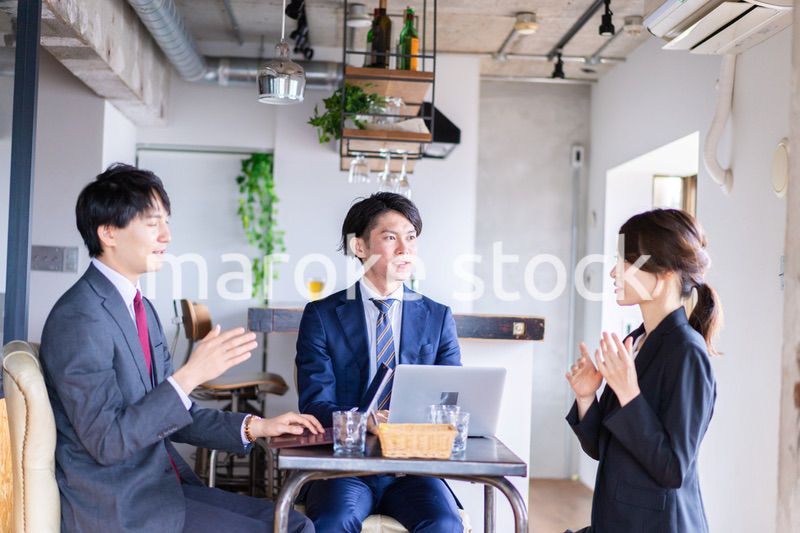 お酒を飲みながら話すビジネスパーソン