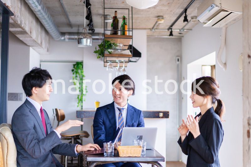 お酒を飲みながら話すビジネスパーソン
