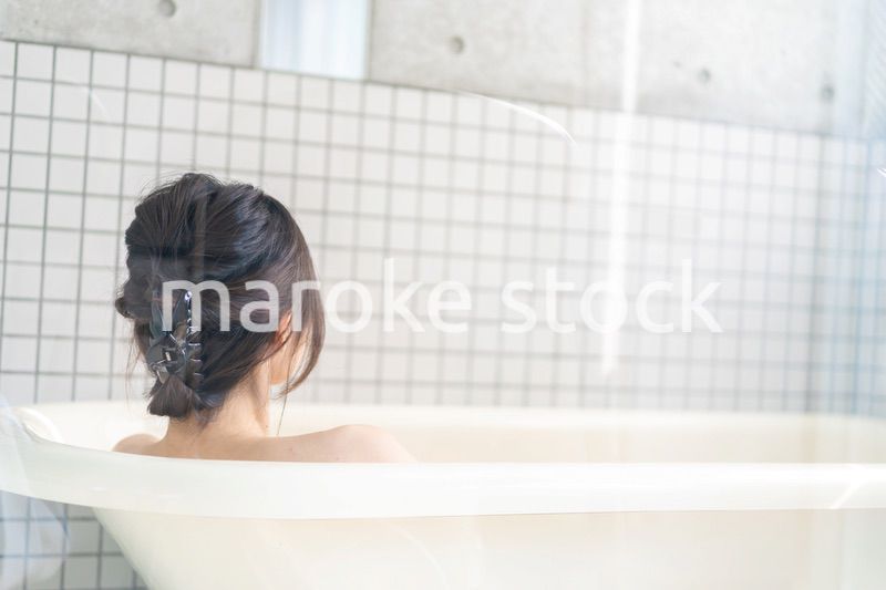 お風呂でシャワーを浴びる若い女性