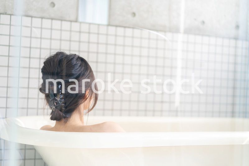 お風呂でシャワーを浴びる若い女性