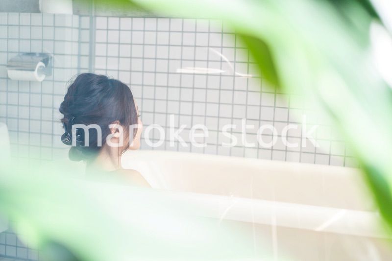 お風呂でシャワーを浴びる若い女性