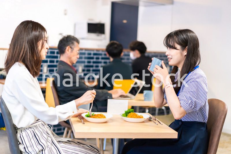 オフィスのカフェテリアのランチを食べる社員
