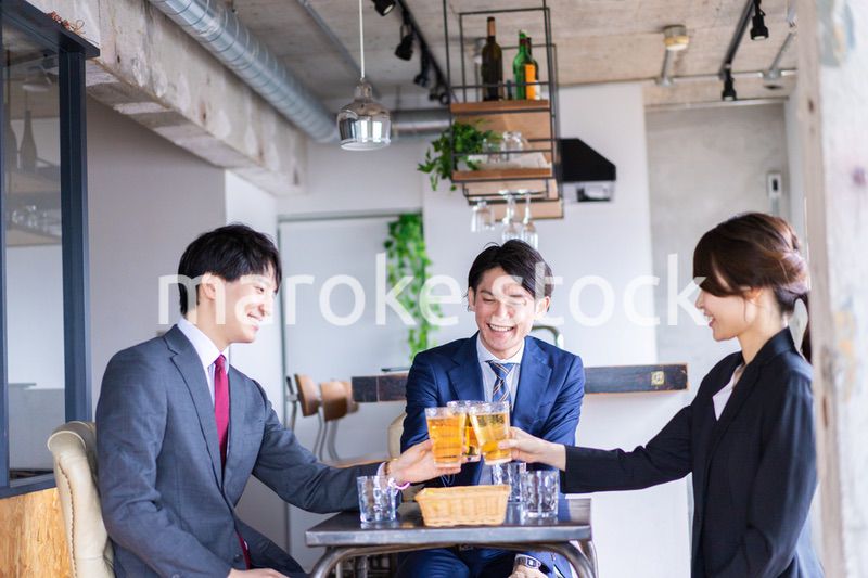 お酒を飲みながら話すビジネスパーソン