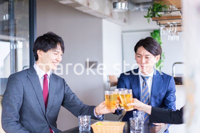 お酒を飲みながら話すビジネスパーソン