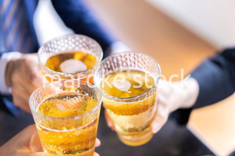 お酒を飲みながら話すビジネスパーソン