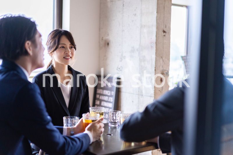 お酒を飲みながら話すビジネスパーソン