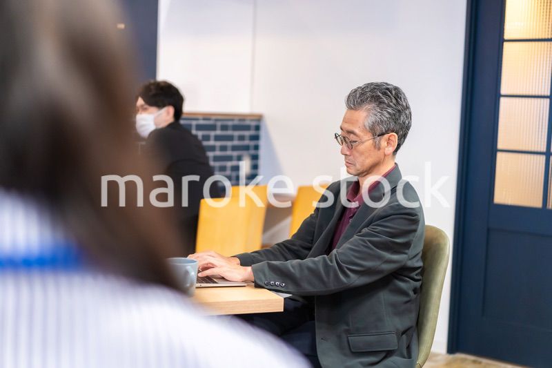 カフェで仕事をする中年男性
