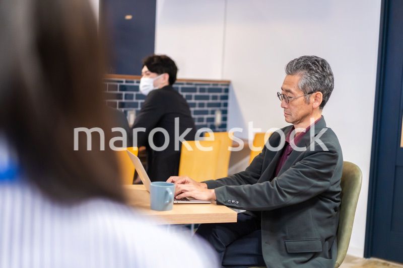 カフェで仕事をする中年男性