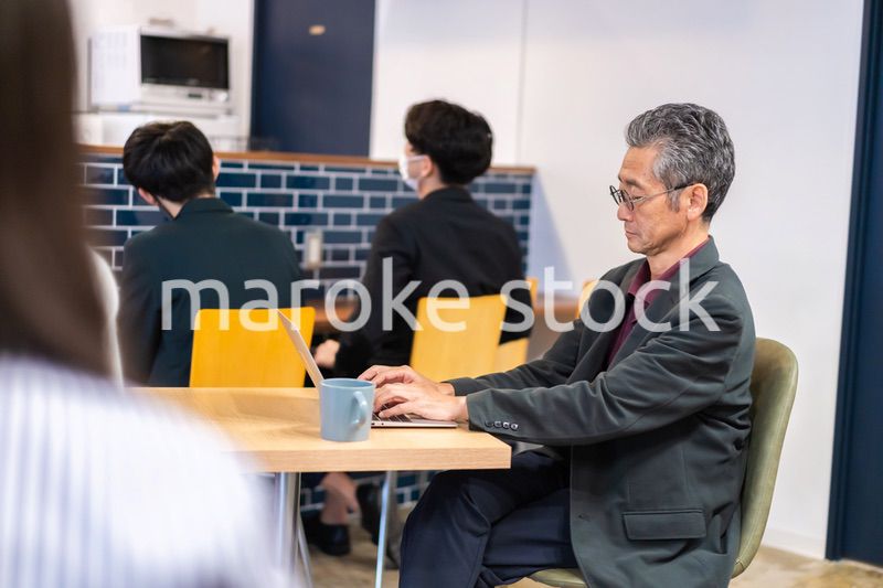 カフェで仕事をする中年男性