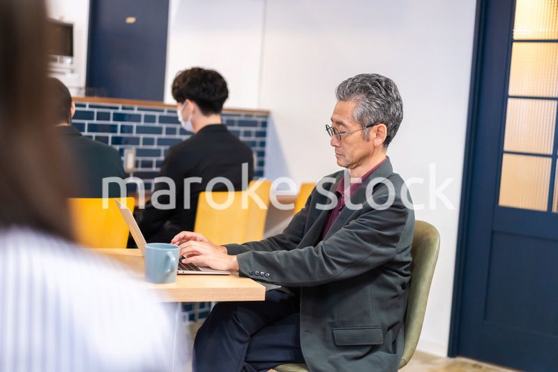 カフェで仕事をする中年男性