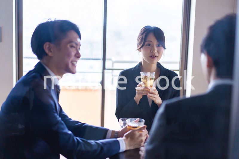 お酒を飲みながら話すビジネスパーソン