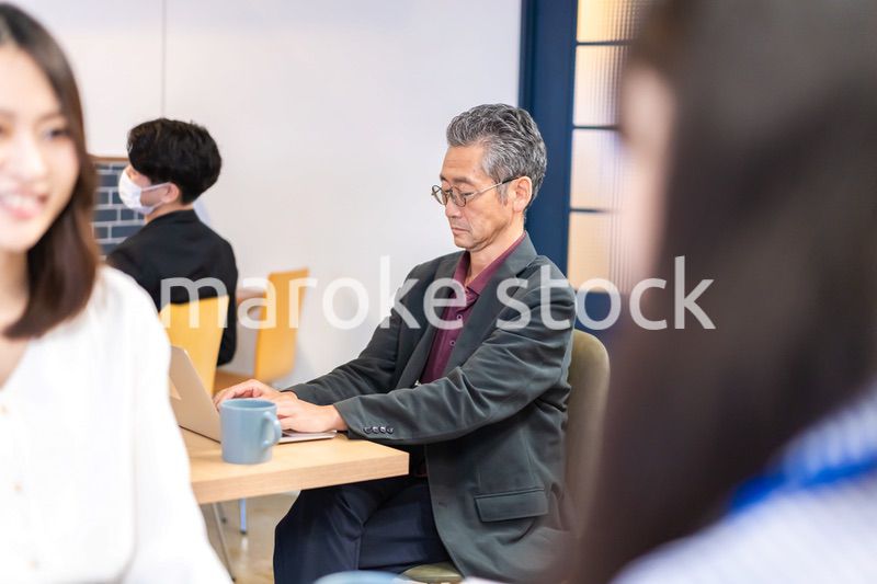 カフェで仕事をする中年男性