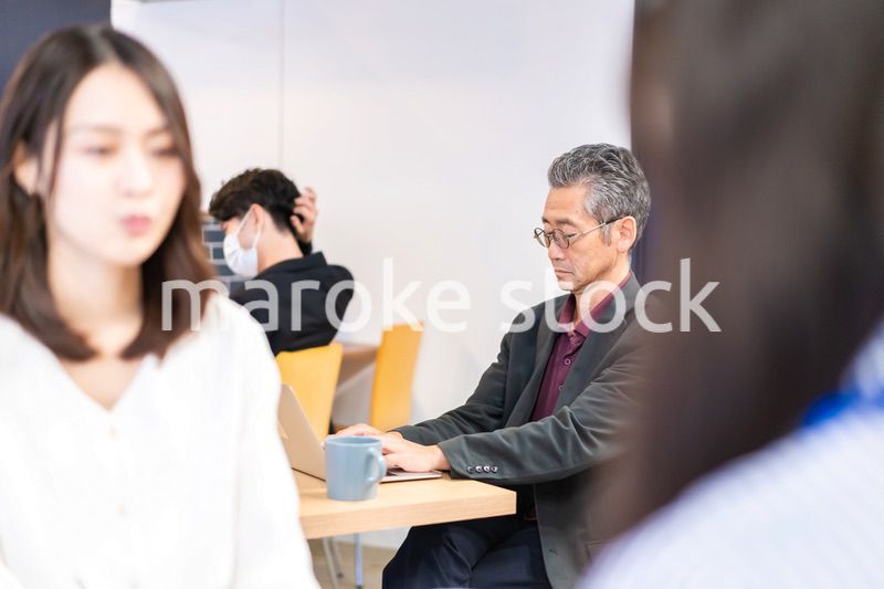 カフェで仕事をする中年男性