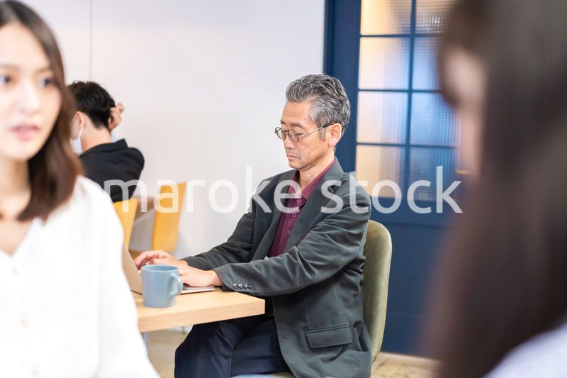カフェで仕事をする中年男性