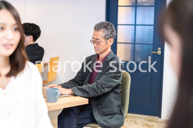 カフェで仕事をする中年男性