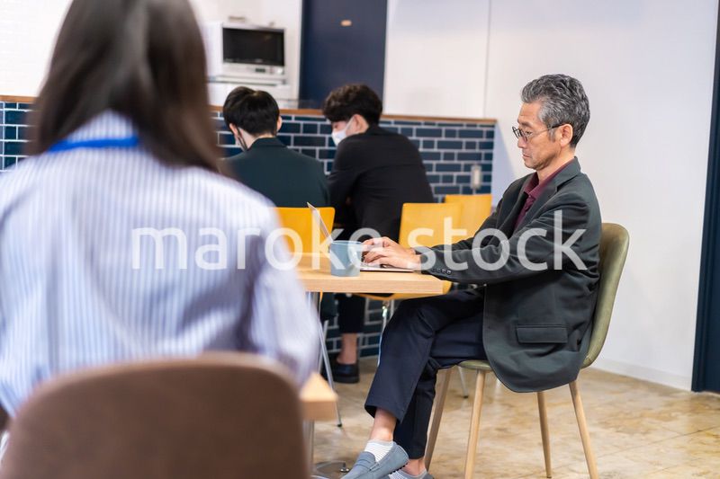 カフェで仕事をする中年男性