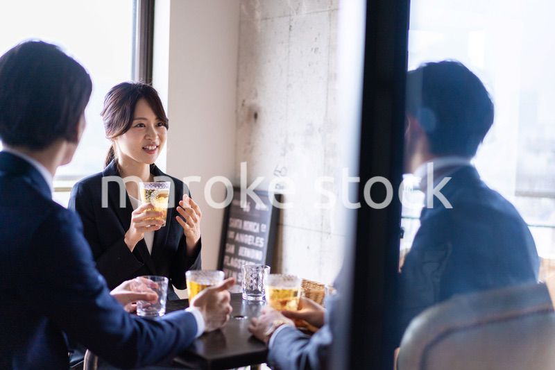 お酒を飲みながら話すビジネスパーソン