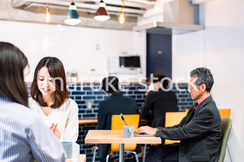 明るい雰囲気の社員食堂でランチを取るオフィスワーカー