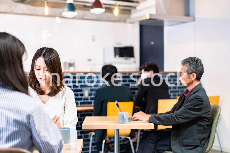 明るい雰囲気の社員食堂でランチを取るオフィスワーカー