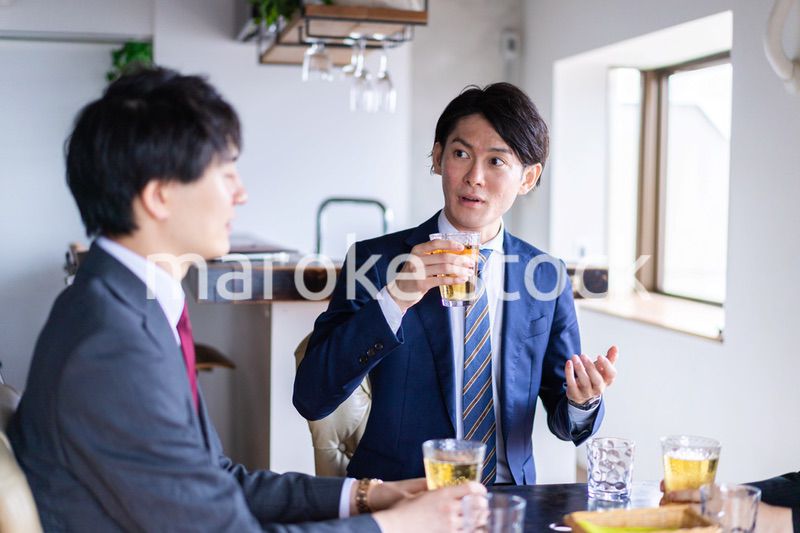 お酒を飲みながら話すビジネスパーソン