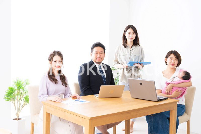 赤ちゃんを連れてオフィスで働く女性