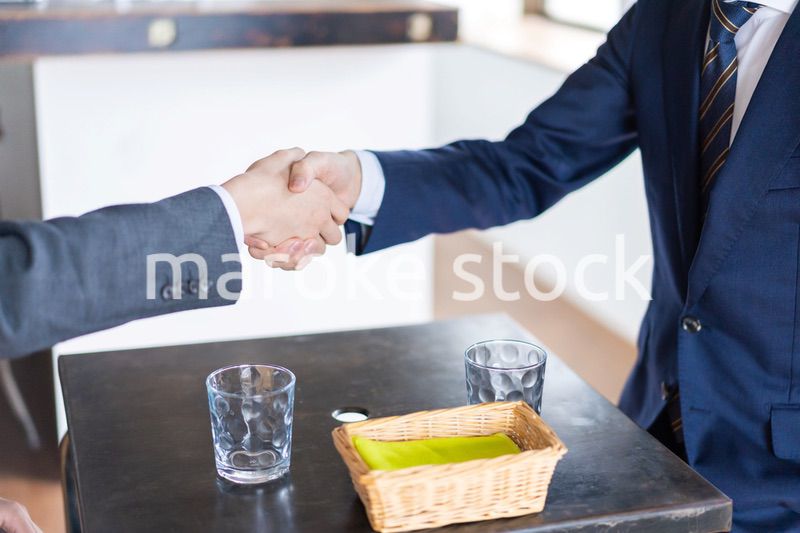 カフェで契約を結ぶビジネスマン