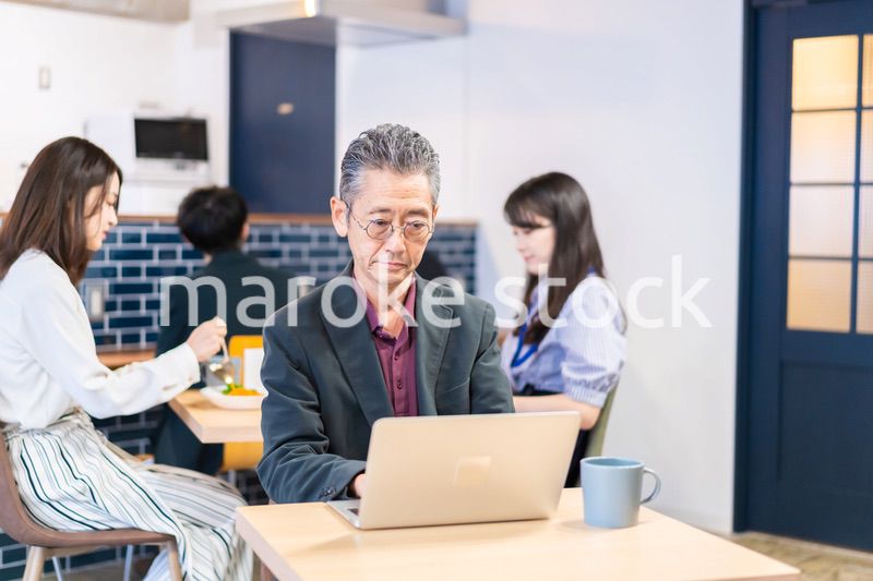 カフェで仕事をする中年男性