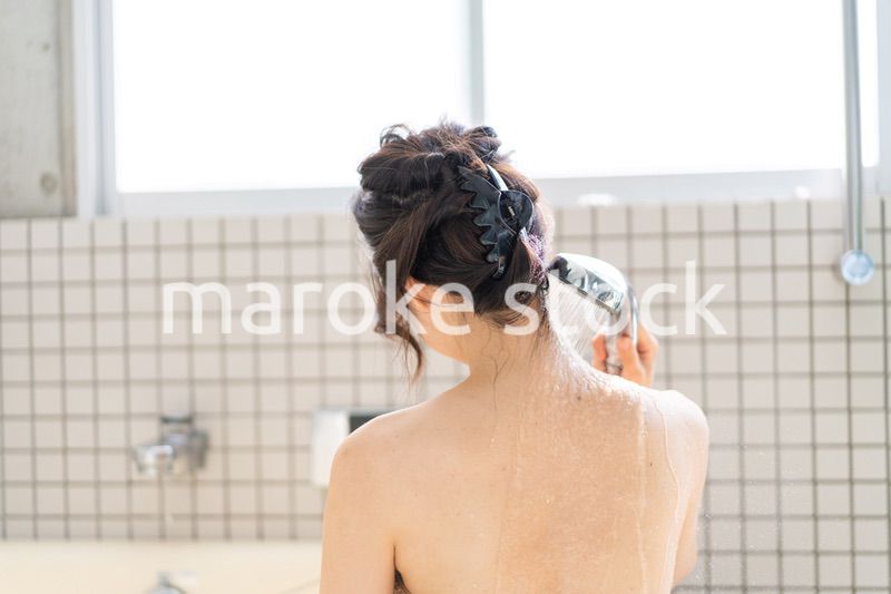 お風呂でシャワーを浴びる若い女性