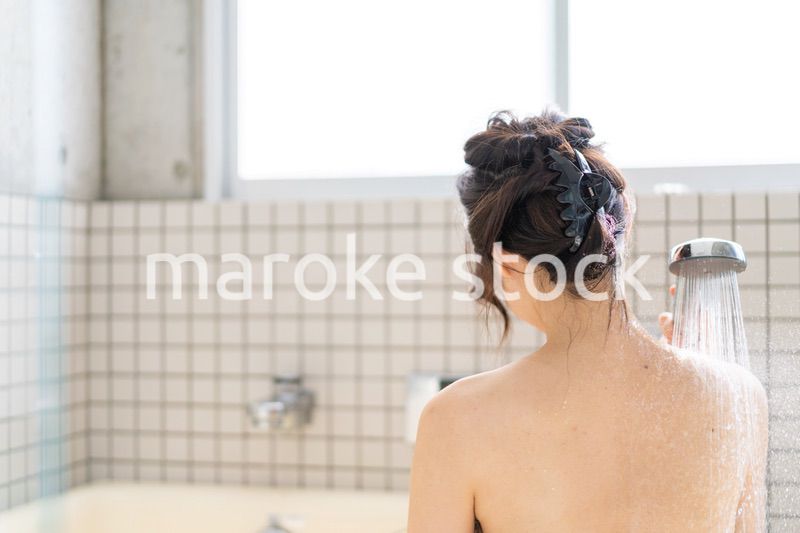 お風呂でシャワーを浴びる若い女性
