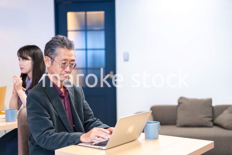 カフェで仕事をする中年男性