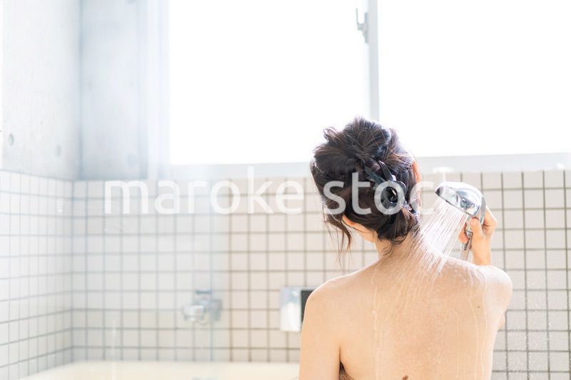 お風呂でシャワーを浴びる若い女性
