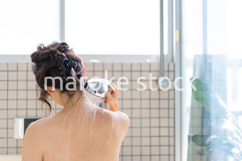 お風呂でシャワーを浴びる若い女性