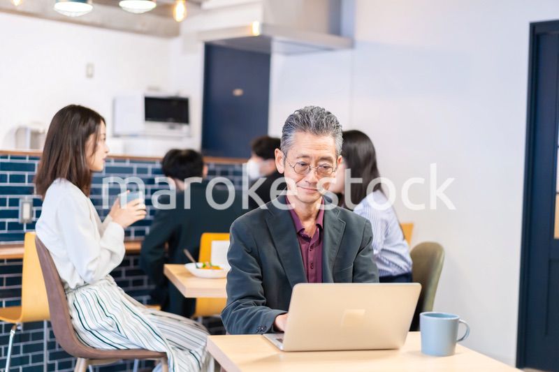 カフェで仕事をする中年男性