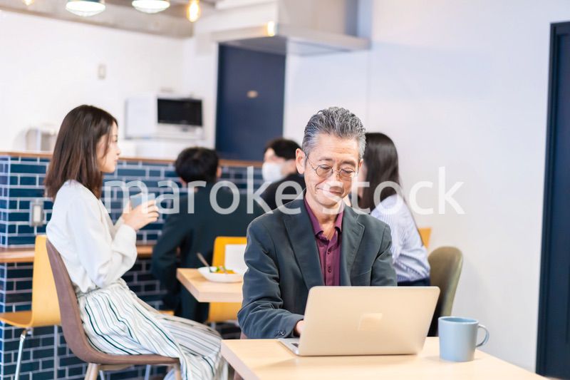 カフェで仕事をする中年男性
